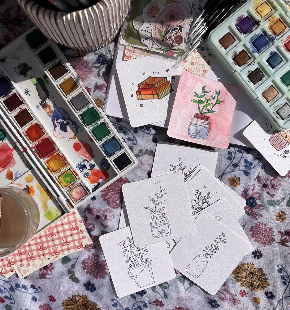 Aquarelles et cartes à colorier sur la table de travail de Marion