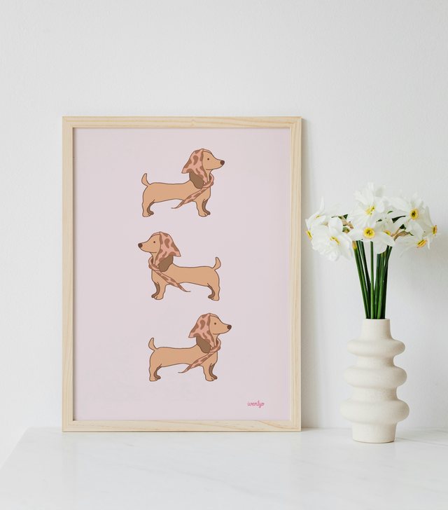 Affiche trio de teckels au foulard léopard encadrée à côté d’un vase de narcisses