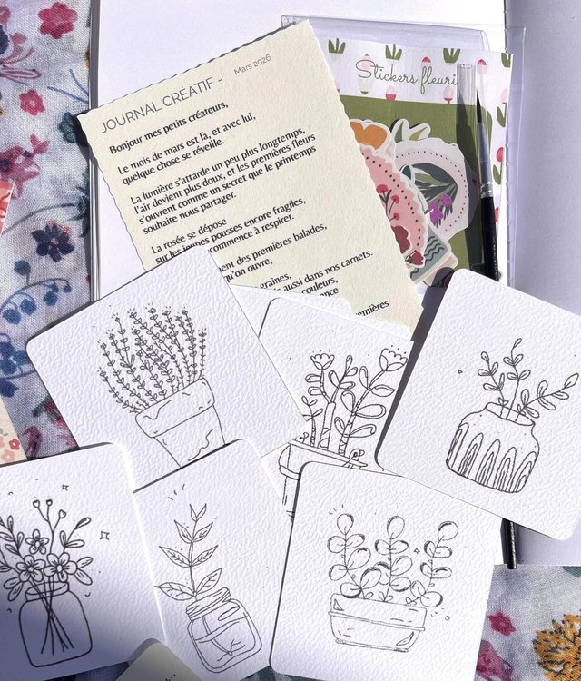 Cartes à colorier du kit créatif posées avec une fiche journal créatif et des stickers fleuris