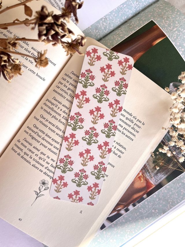 Marque-page fleurs indiennes roses glissé dans un livre ouvert