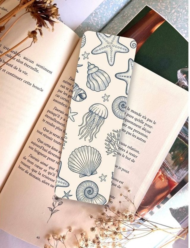 Marque-page monde marin glissé dans un livre ouvert