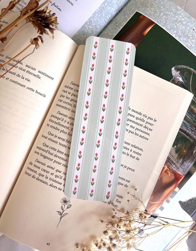Marque-page tulipes roses et rayures vert sauge glissé dans un livre ouvert