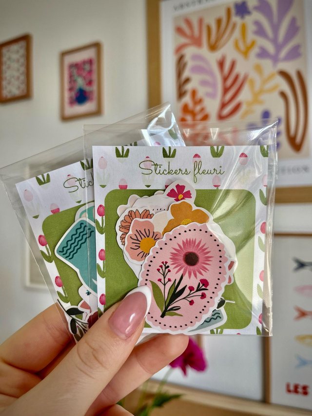 Packs de stickers fleuris Iventyo tenus en main, sachets transparents