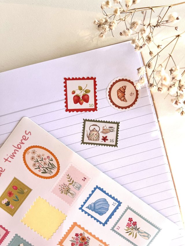 Stickers timbres fraises, croissant et coquillage décollés sur une page