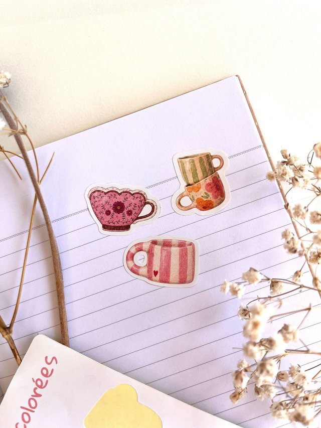 Stickers tasses illustrées décollés et posés sur une page lignée
