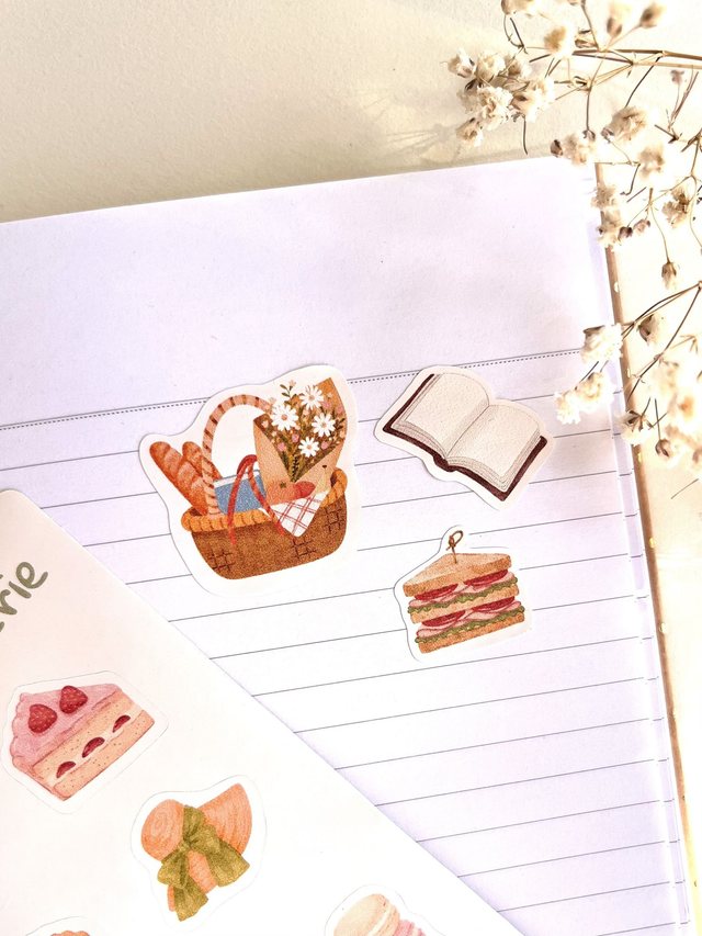 Stickers panier de pique-nique, sandwich et livre décollés sur un carnet