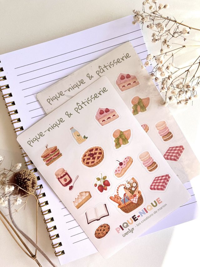Deux planches de stickers pique-nique et pâtisserie posées sur un carnet